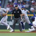 
              Texas Rangers' Marcus Semien (2) steals second base as Toronto Blue Jays' Matt Chapman, left, and Bo Bichette, rear, move to cover third base as umpire Todd Tichenor, second from left, looks on in the first inning of baseball game in Arlington, Texas, Saturday, Sept. 10, 2022. (AP Photo/Tony Gutierrez)
            