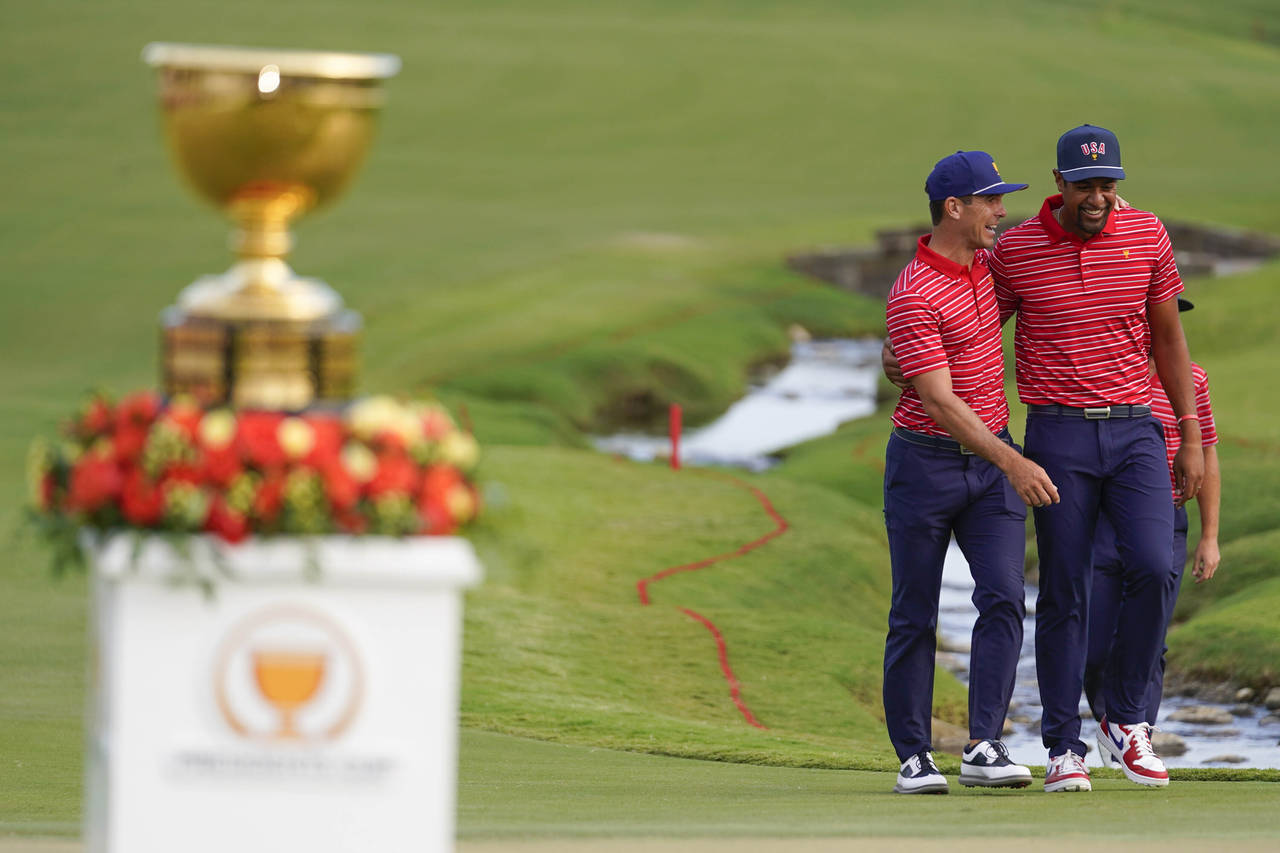 Billy Horschel, left, walks with Tony Finau after the USA team defeated the international team in m...