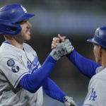 
              Los Angeles Dodgers' Freddie Freeman, left, celebrates with first base coach Clayton McCullough after hitting an RBI single during the sixth inning of the team's baseball game against the San Diego Padres, Thursday, Sept. 29, 2022, in San Diego. (AP Photo/Gregory Bull)
            