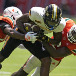 
              Miami safety Kamren Kinchens, left, and cornerback Tyrique Stevenson, right, take down Southern Miss wide receiver Jason Brownlee during the first half of an NCAA college football game, Saturday, Sept. 10, 2022, in Miami Gardens, Fla. (AP Photo/Wilfredo Lee)
            