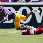 
              East Carolina's C.J. Johnson (5) stretches for extra yards in the grasp of North Carolina State's Cyrus Fagan (4) during the first half of an NCAA college football game in Greenville, N.C., Saturday, Sept. 3, 2022. (AP Photo/Karl B DeBlaker)
            