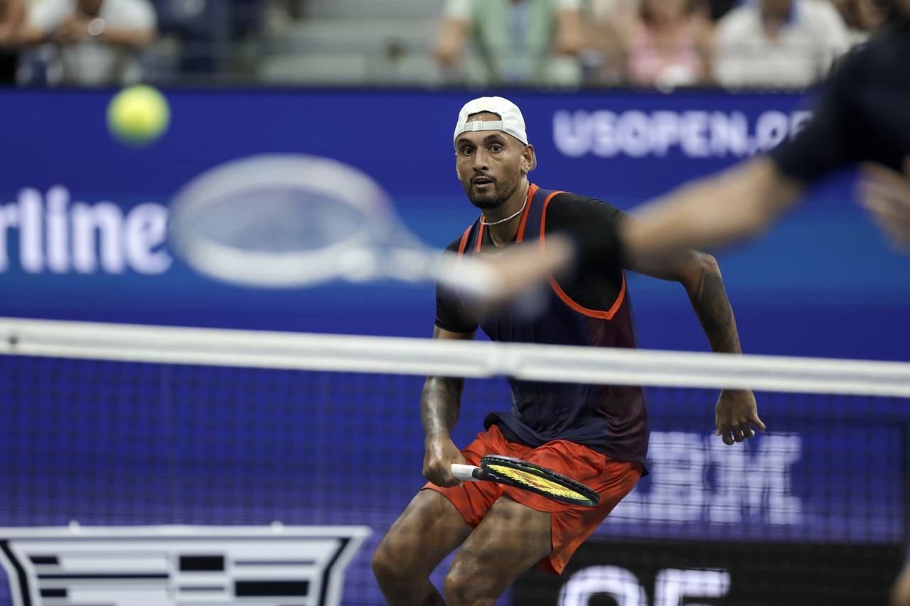 Nick Kyrgios, of Australia, moves to return a shot from Daniil Medvedev, front, of Russia, during t...