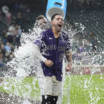 
              Colorado Rockies' Randal Grichuk is doused by Charlie Blackmon while being interviewed after the team's baseball game against the Milwaukee Brewers on Tuesday, Sept. 6, 2022, in Denver. Grichuk hit a three-run home run for the victory. (AP Photo/David Zalubowski)
            