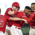 
              Los Angeles Angels' Magneuris Sierra, center, celebrates with Matt Duffy (5), Chad Wallach, second from left, and Luis Rengifo (2) after hitting a single on a bunt, causing Andrew Velazquez to score during the tenth inning of a baseball game against the Detroit Tigers in Anaheim, Calif., Tuesday, Sept. 6, 2022. The Angels won 5-4. (AP Photo/Ashley Landis)
            