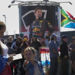 
              Fans wait for F1 rdrivers to arrive as a billboard of Red Bull driver Max Verstappen of The Netherlands is seen at the Zandvoort racetrack, Netherlands, Thursday, Sept. 1, 2022, ahead of Sunday's Formula One Dutch Grand Prix auto race. (AP Photo/Peter Dejong)
            