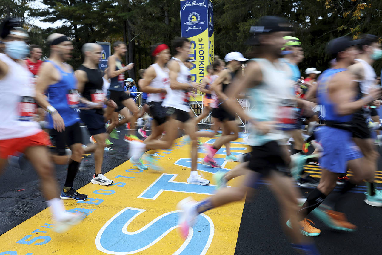FILE - Runners cross the starting line of the 125th Boston Marathon, Monday, Oct. 11, 2021, in Hopk...