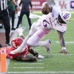 
              Kansas quarterback Jalon Daniels (6) leaps into the end zone for a touchdown past Houston defensive lineman Nelson Ceaser during the second half of an NCAA college football game, Saturday, Sept. 17, 2022, in Houston. (AP Photo/Eric Christian Smith)
            