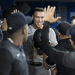 
              New York Yankees' Aaron Judge is congratulated in the dugout after his 61st home run of the season, a two-run shot, against the Toronto Blue Jays during the seventh inning of a baseball game Wednesday, Sept. 28, 2022, in Toronto. (Nathan Denette/The Canadian Press via AP)
            