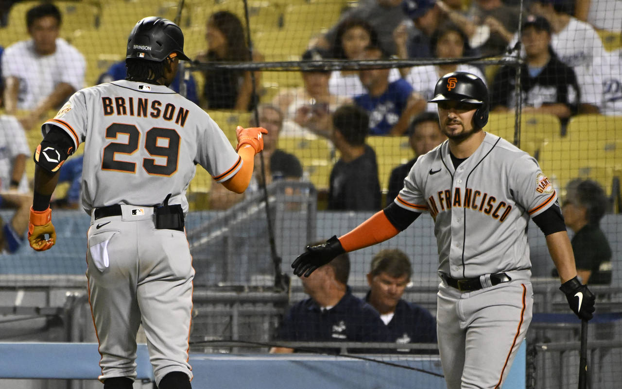 San Francisco Giants' Lewis Brinson points to J.D. Davis (7) after hitting a home run against the L...