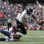 
              Baltimore Ravens quarterback Lamar Jackson (8) scores a touchdown as New England Patriots safety Devin McCourty (32), below left, tries to defend in the second half of an NFL football game, Sunday, Sept. 25, 2022, in Foxborough, Mass. (AP Photo/Michael Dwyer)
            