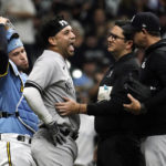 
              New York Yankees' Marwin Gonzalez, middle, reacts as he's checked on by a trainer after being hit by an errant throw from Milwaukee Brewers' Victor Caratini during the third inning of a baseball game Saturday, Sept. 17, 2022, in Milwaukee. Gonzalez exited the game. (AP Photo/Aaron Gash)
            