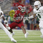 
              Fresno State wide receiver Erik Brooks tries to get past Cal Poly defenders Dylan Watt, left, and Xavier Oliphant during the first half of an NCAA college football game in Fresno, Calif., Thursday, Sept. 1, 2022. (AP Photo/Gary Kazanjian)
            