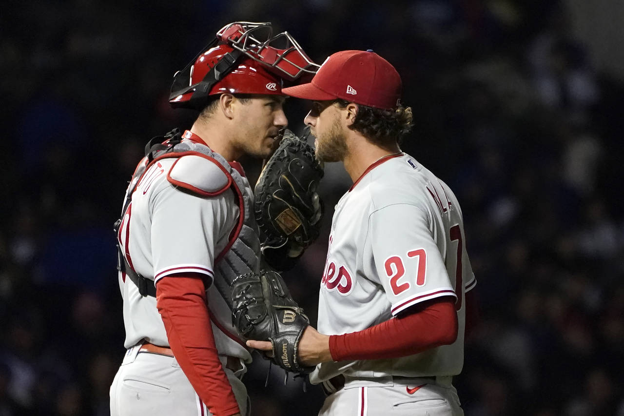 Philadelphia Phillies catcher J.T. Realmuto talks with starting pitcher Aaron Nola during the fifth...
