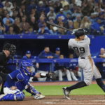 
              New York Yankees' Aaron Judge (99) swings at and misses a pitch next to Toronto Blue Jays catcher Alejandro Kirk during the sixth inning of a baseball game Tuesday, Sept. 27, 2022, in Toronto. (Nathan Denette/The Canadian Press via AP)
            
