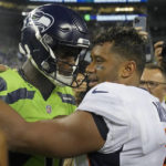 
              Seattle Seahawks quarterback Geno Smith, left, talks with Denver Broncos quarterback Russell Wilson, right, after an NFL football game, Monday, Sept. 12, 2022, in Seattle. The Seahawks won 17-16. (AP Photo/Stephen Brashear)
            