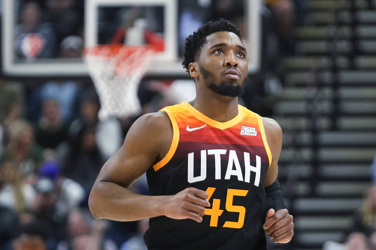 FILE - Utah Jazz guard Donovan Mitchell (45) looks at the scoreboard as he runs up the court during...