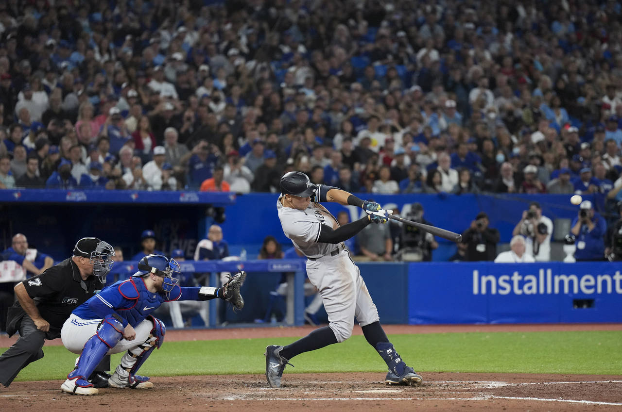 New York Yankees' Aaron Judge hits a two-run home run, his 61st homer of the season, next to Toront...