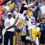 
              Mississippi State wide receiver Rara Thomas (0) makes a reception over LSU defensive back Colby Richardson (22) to score a touchdown during the first half of an NCAA college football game in Baton Rouge, La., Saturday, Sept. 17, 2022. (AP Photo/Tyler Kaufman)
            