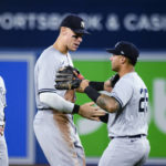 
              New York Yankees' Aaron Judge, center, celebrates with Gleyber Torres (25) after the team's 5-2 win over the Toronto Blue Jays in a baseball game Tuesday, Sept. 27, 2022, in Toronto. (Christopher Katsarov/The Canadian Press via AP)
            
