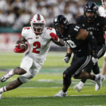 
              Western Kentucky running back Davion Ervin-Poindexter (2) gets around the Hawaii defense during the first half of an NCAA college football game Saturday, Sept. 3, 2022, in Honolulu. (AP Photo/Marco Garcia)
            