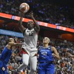 
              Las Vegas Aces' Chelsea Gray (12) goes up for a basket as Connecticut Sun's DeWanna Bonner, left, and Brionna Jones (42) defend during the second half in Game 4 of a WNBA basketball final playoff series, Sunday, Sept. 18, 2022, in Uncasville, Conn. (AP Photo/Jessica Hill)
            