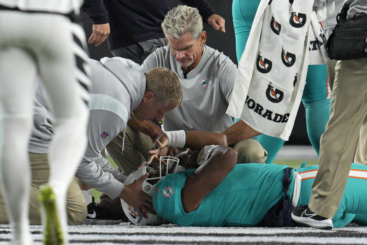Miami Dolphins quarterback Tua Tagovailoa is examined during the first half of the team's NFL footb...