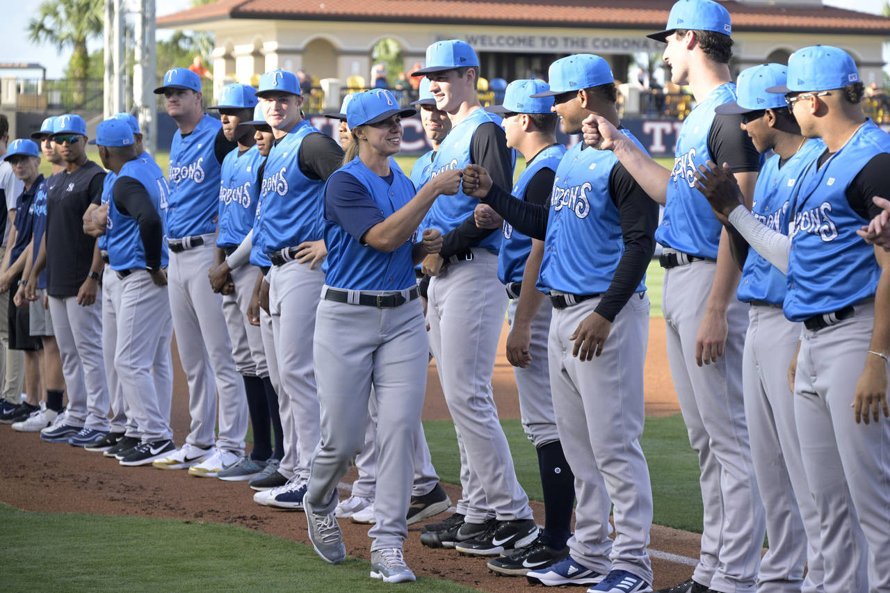 FILE - Tampa Tarpons manager Rachel Balkovec, center, exchanges fist bumps with her players, while ...