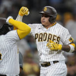 
              San Diego Padres' Manny Machado, right, celebrates with teammate Josh Bell after hitting a home run during the sixth inning of a baseball game against the Los Angeles Dodgers, Saturday, Sept. 10, 2022, in San Diego. (AP Photo/Gregory Bull)
            