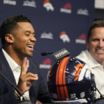 
              Denver Broncos quarterback Russell Wilson, left, laughs as he describes a late-night video call to general manager George Paton, right, during a news conference to announce that Wilson had signed a five-year contract extension worth $245 million, Thursday, Sept. 1, 2022, at the NFL football team's headquarters in Centennial, Colo. (AP Photo/David Zalubowski)
            