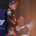 
              Dutch professional kickboxer Rico Verhoeven lifts his friend Red Bull driver Max Verstappen of the Netherlands for the fans after he clocked the fastest time in the qualifying session ahead of Sunday's Formula One Dutch Grand Prix auto race, at the Zandvoort racetrack, in Zandvoort, Netherlands, Saturday, Sept. 3, 2022. (AP Photo/Peter Dejong)
            
