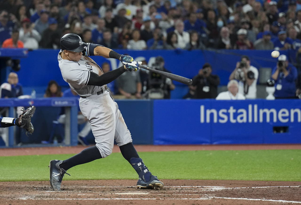 New York Yankees' Aaron Judge hits a two-run home run, his 61st homer of the season, during the sev...