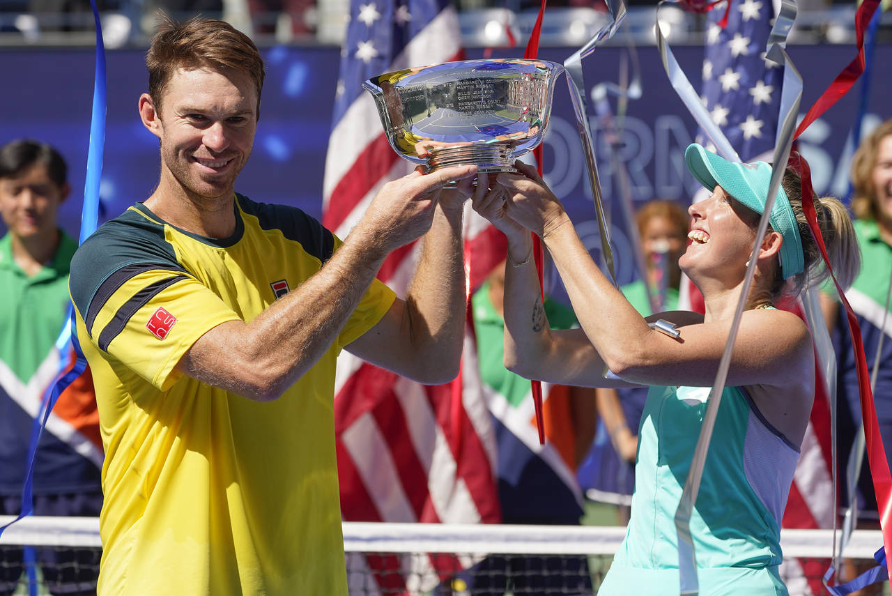 John Peers, left, and Storm Sanders, of Australia, hold up the championship trophy after winning th...