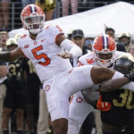 
              Clemson quarterback DJ Uiagalelei (5) looks to pass as Wake Forest defensive lineman Jasheen Davis (30) tries to tackle him during the second half of an NCAA college football game in Winston-Salem, N.C., Saturday, Sept. 24, 2022. (AP Photo/Chuck Burton)
            