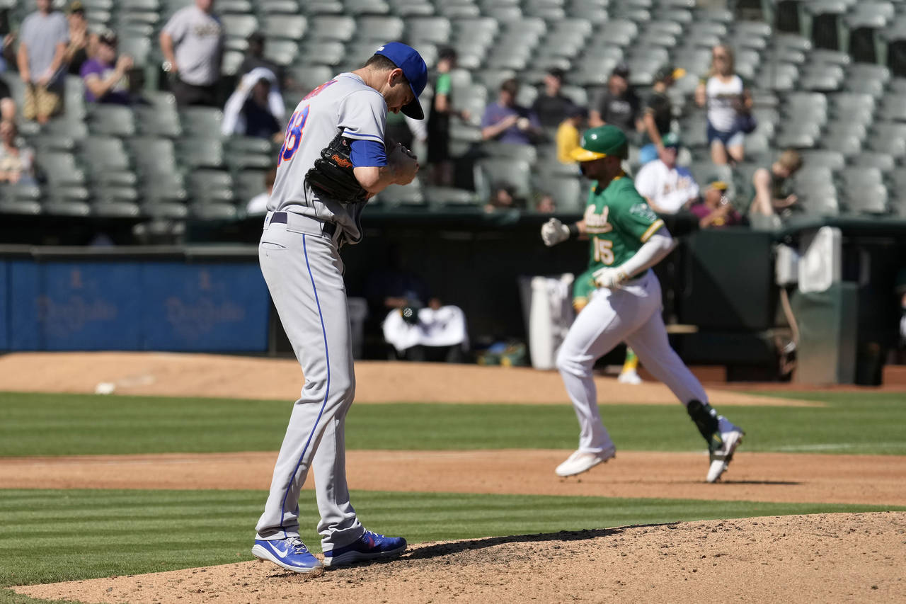 New York Mets starting pitcher Jacob deGrom, left, stands on the mound as Oakland Athletics' Seth B...