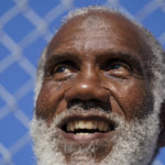 
              Earl Wilson smiles as he watches a tennis match between fellow San Quentin State Prison inmates and a group of visiting players in San Quentin, Calif., Saturday, Aug. 13, 2022. (AP Photo/Godofredo A. Vásquez)
            
