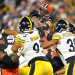
              Cleveland Browns running back Nick Chubb, top, leaps into the end zone for a touchdown during the second half of the team's NFL football game against the Pittsburgh Steelers in Cleveland, Thursday, Sept. 22, 2022. (AP Photo/David Richard)
            
