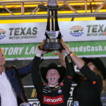 
              Tyler Reddick lifts the winners trophy in victory lane after winning the the NASCAR Cup Series auto race at Texas Motor Speedway in Fort Worth, Texas, Sunday, Sept. 25, 2022. (AP Photo/Larry Papke)
            