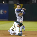 
              Seattle Mariners second baseman Adam Frazier, top, throws to first base after forcing Oakland Athletics' Chad Pinder (10) out at second base on a double play hit into by Dermis Garcia during the fourth inning of a baseball game in Oakland, Calif., Wednesday, Sept. 21, 2022. (AP Photo/Jeff Chiu)
            