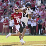 
              Cincinnati receiver Nick Mardner (84) makes a touchdown catch in front of Arkansas defensive back LaDarrius Bishop (11) during the second half of an NCAA college football game Saturday, Sept. 3, 2022, in Fayetteville, Ark. (AP Photo/Michael Woods)
            