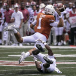 
              Texas quarterback Hudson Card (1) throws the ball away to avoid a sack by Alabama defensive back Kool-Aid McKinstry (1) during the first half of an NCAA college football game, Saturday, Sept. 10, 2022, in Austin, Texas. (AP Photo/Rodolfo Gonzalez)
            