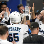 
              Miami Marlins' Jordan Groshans (65) is congratulated in the dugout after hitting a solo home run during the third inning of the team's baseball game against the Philadelphia Phillies, Thursday, Sept. 15, 2022, in Miami. (AP Photo/Lynne Sladky)
            