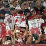 
              Fans hold up pictures of Los Angeles Angels' Shohei Ohtani and his interpreter Ippei Mizuhara while he bats during the sixth inning of a baseball game against the Seattle Mariners Friday, Sept. 16, 2022, in Anaheim, Calif. (AP Photo/Mark J. Terrill)
            