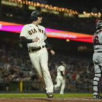 
              San Francisco Giants' Mike Yastrzemski, left, scores against the Atlanta Braves on a single by Thairo Estrada during the fifth inning of a baseball game in San Francisco, Monday, Sept. 12, 2022. (AP Photo/Godofredo A. Vásquez)
            