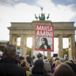 
              Demonstrators attend a protest against the death of Iranian Mahsa Amini in Berlin, Germany, Wednesday, Sept. 28, 2022. Amini, a 22-year-old woman who died in Iran while in police custody, was arrested by Iran's morality police for allegedly violating its strictly-enforced dress code. (Kay Nietfeld/dpa via AP)
            