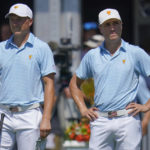 
              Jordan Spieth and Justin Thomas watch play at the first tee during their foursomes match at the Presidents Cup golf tournament at the Quail Hollow Club, Thursday, Sept. 22, 2022, in Charlotte, N.C. (AP Photo/Julio Cortez)
            