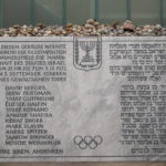 
              A memorial plaque for the eleven athletes from Israel and one German police officer were killed in a terrorist attack during the Olympic Games 1972, stands at the former accommodation of the Israeli team in the Olympic village in Munich, Germany, Saturday, Aug. 27, 2022. The families of 11 Israeli athletes killed by Palestinian attackers at the 1972 Summer Olympics and the German government are close to reaching a deal over the long-disputed amount of the compensation. (AP Photo/Matthias Schrader)
            
