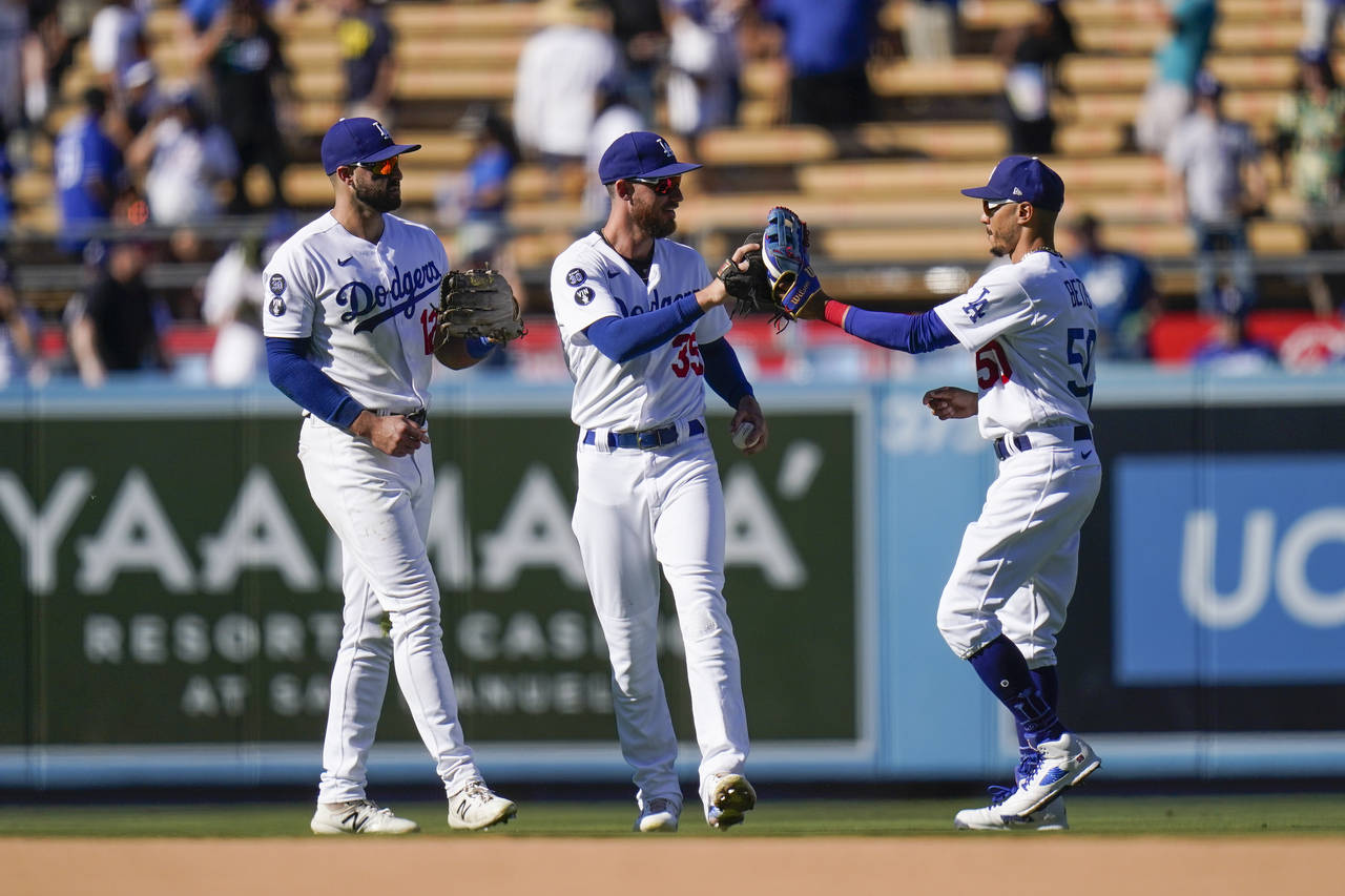 From left to right, Los Angeles Dodgers' Joey Gallo, Cody Bellinger and Mookie Betts celebrate a wi...