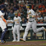 
              Oakland Athletics' Sean Murphy (12) scores as Houston Astros catcher Christian Vazquez stands at home plate during the seventh inning of a baseball game Saturday, Sept. 17, 2022, in Houston. (AP Photo/David J. Phillip)
            