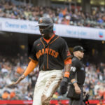 
              San Francisco Giants' Lewis Brinson, in front, reacts after scoring against the Los Angeles Dodgers during the fifth inning of a baseball game in San Francisco, Sunday, Sept. 18, 2022. (AP Photo/John Hefti)
            