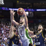 
              Lithuania's Domantas Sabonis, center, is challenged by Bosnia-Herzegovina's Miralem Halilovic, left, and Jusuf Nurkic, right, during their Eurobasket group B basketball match in Cologne, Germany, Wednesday, Sept. 7, 2022. (Federico Gambarini/dpa via AP)
            